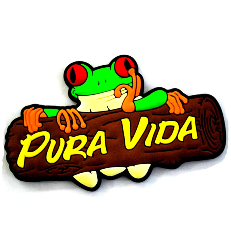 Soft PVC magnet of a green red eyed tree frog lying on a brown log above the words Pura Vida