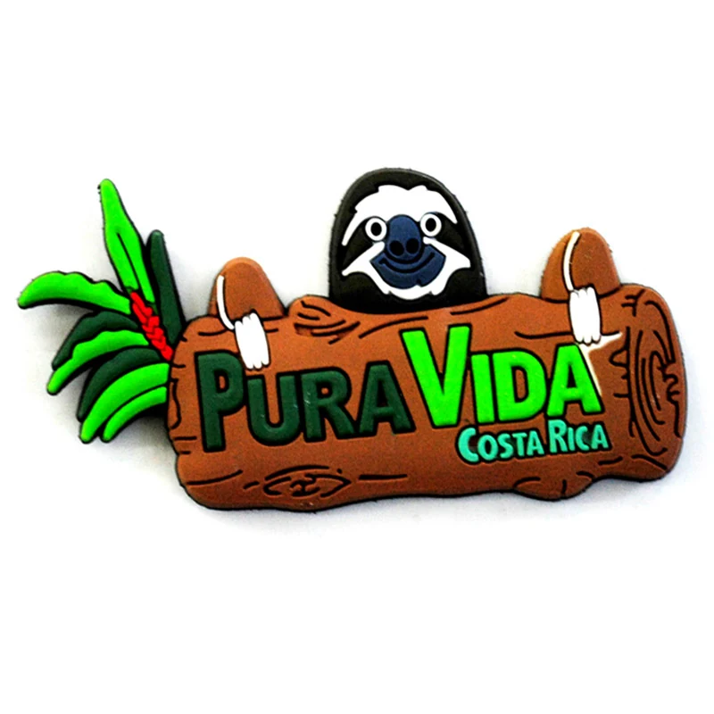 Soft PVC magnet of a sloth hanging over a brown log reading Pura Vida Costa Rica with green leaves