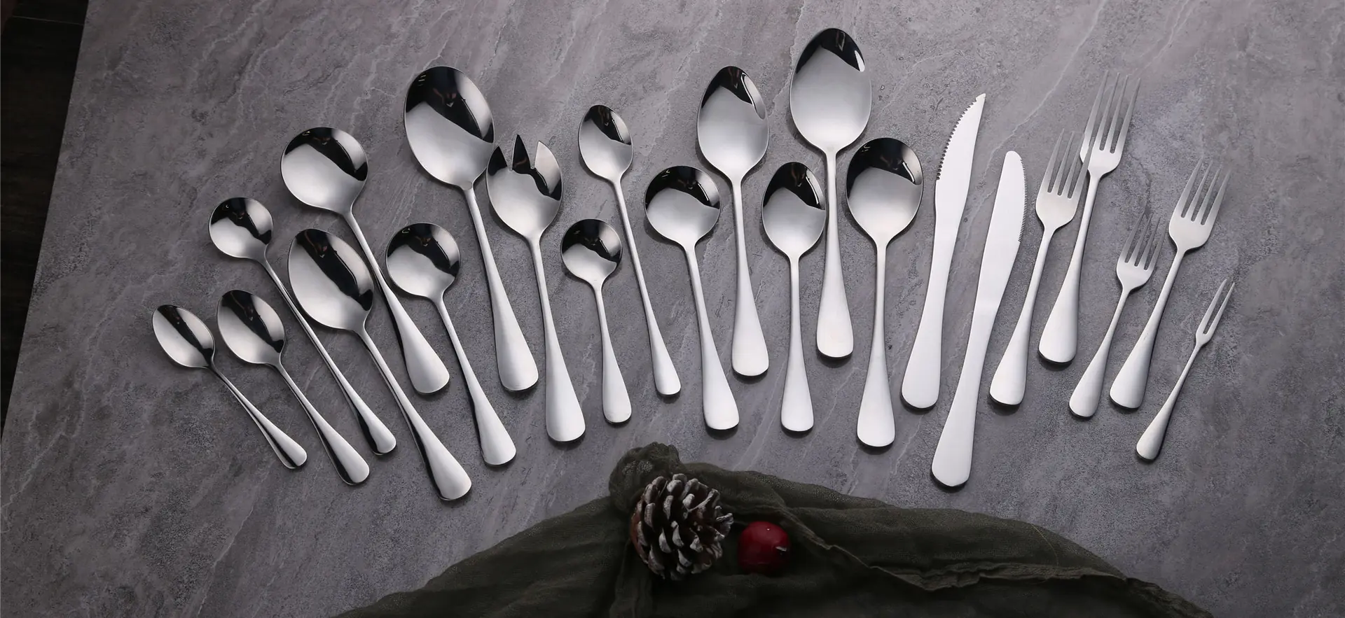 Stainless steel flatware set laid out on slate
