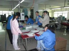 Operators cutting and assembling polypropylene folder bodies on the shop floor.