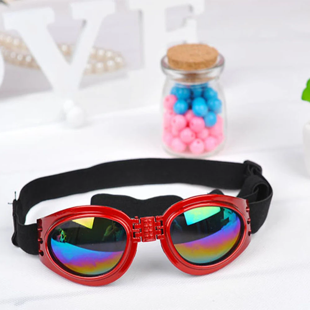 Red steampunk goggles with rainbow reflective lenses and a black elastic strap.