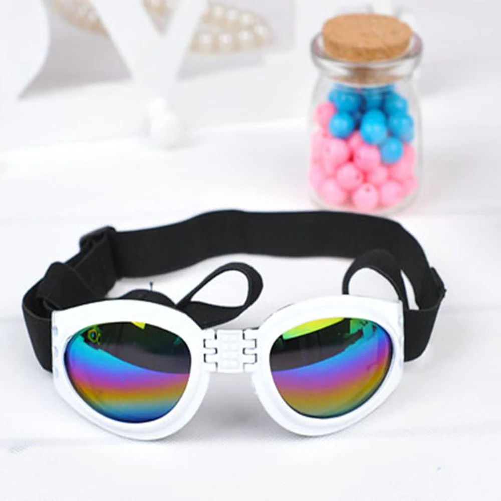 White framed goggles with rainbow reflective lenses and black strap on white surface