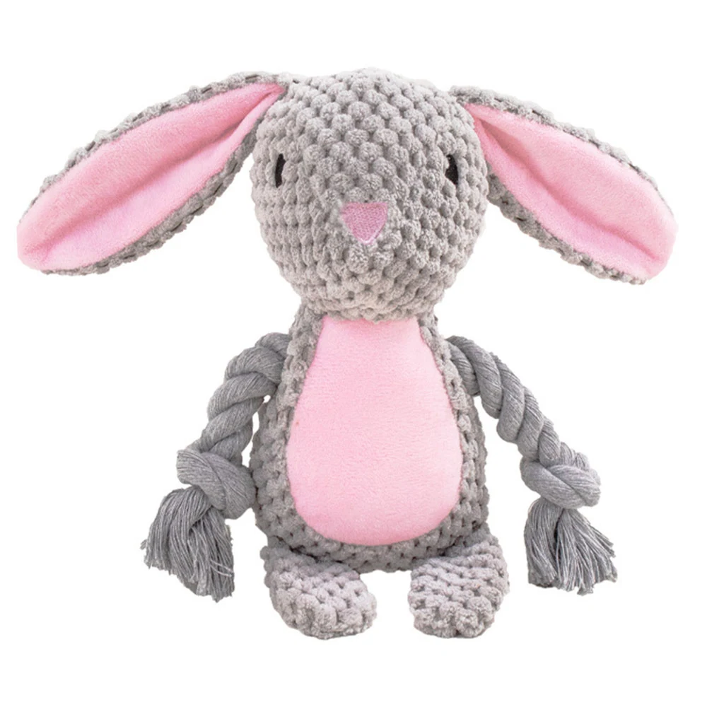 Grey crocheted bunny toy with pink inner ears and belly, sitting upright with braided arms.