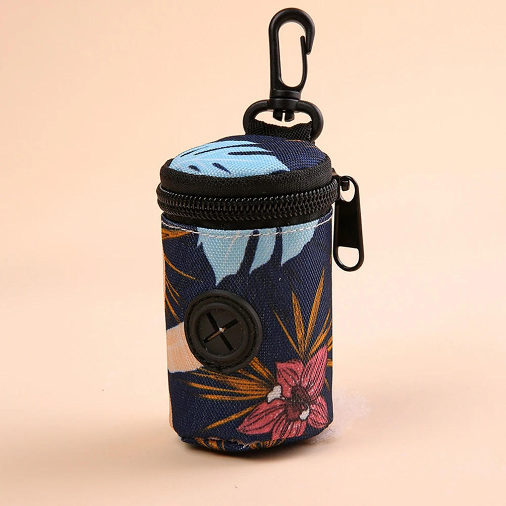 A cylindrical fabric bag featuring a blue and pink tropical leaf pattern, equipped with a zipper and a black carabiner clip.