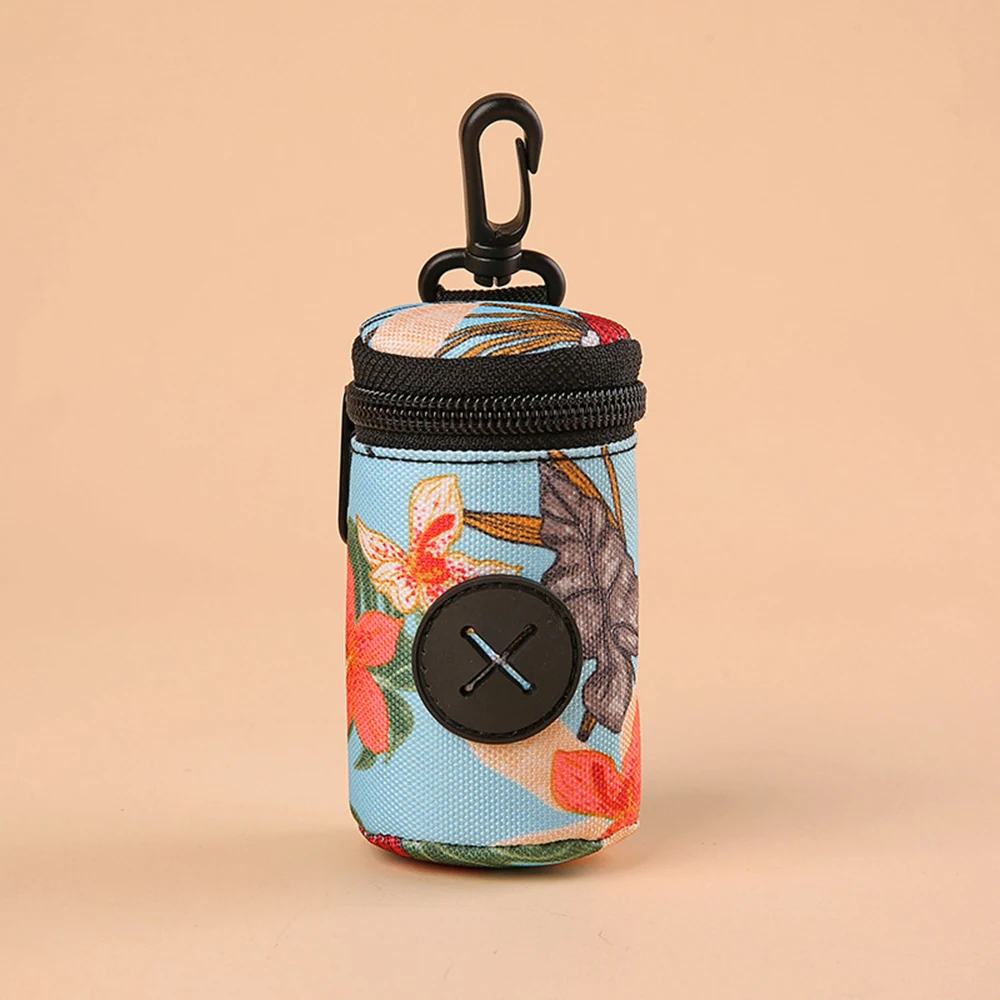 Small cylindrical fabric bag with floral pattern, black zipper, and carabiner clip.
