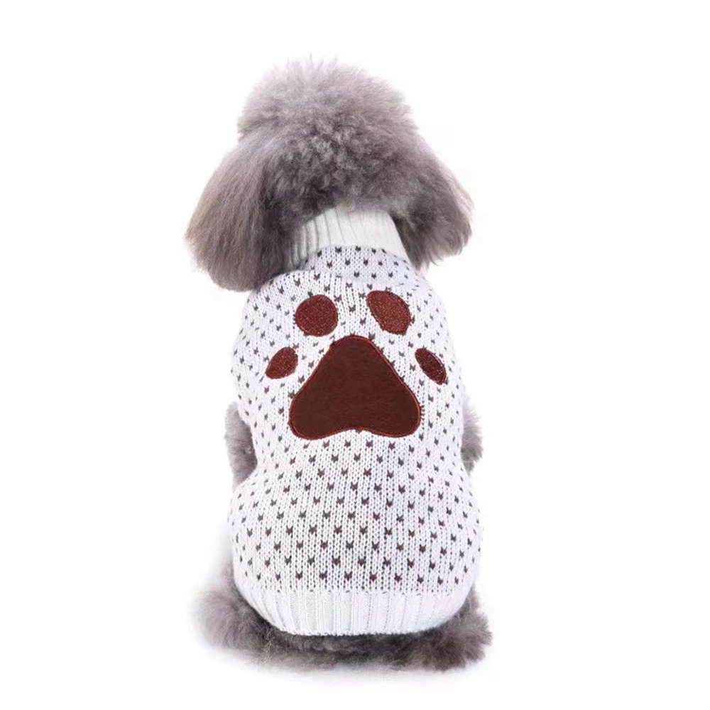 Back view of a grey poodle wearing a white knitted sweater with a brown paw print design.