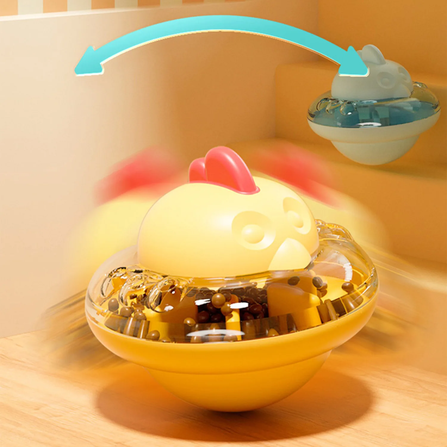 Yellow rooster toy with a clear spinning base and a blue arrow indicating motion.