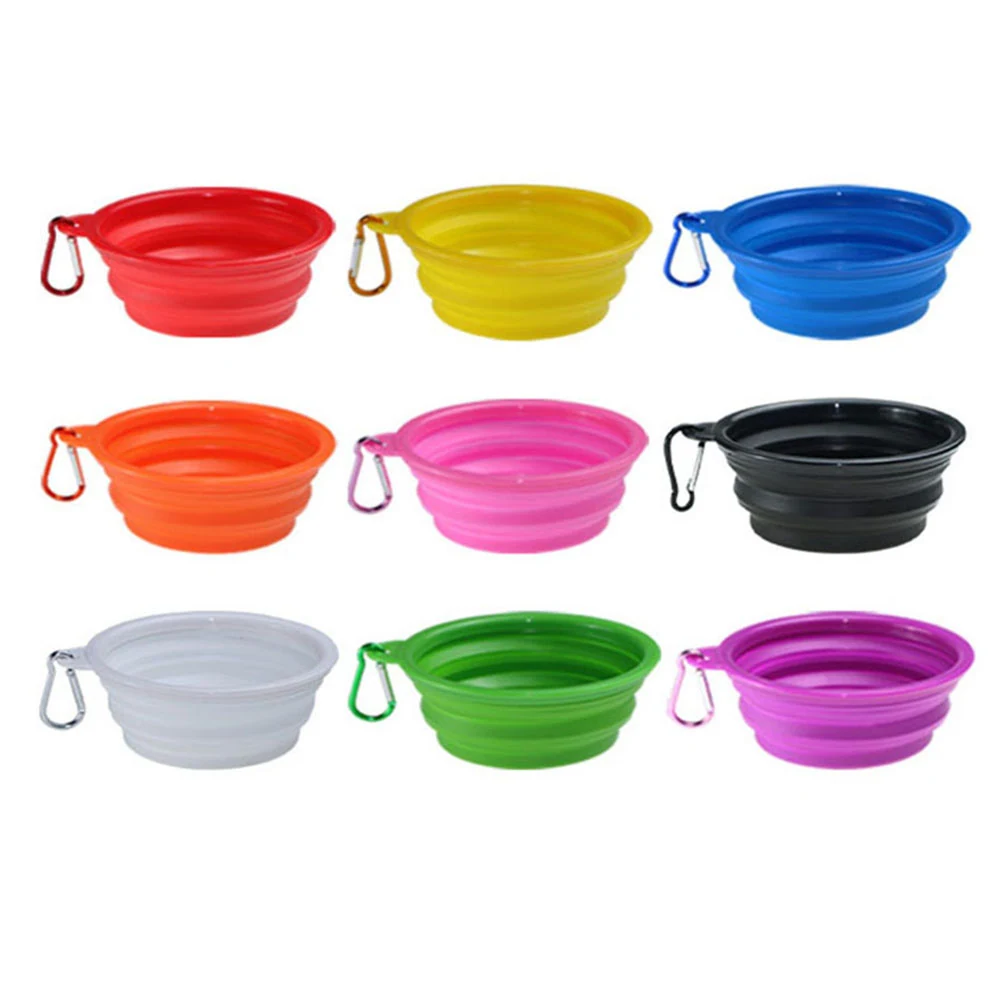 Nine collapsible silicone dog bowls in assorted colors with carabiner clips arranged on a white background.