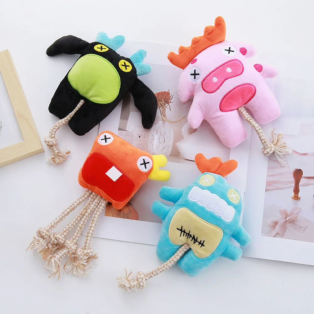 Four colorful plush monster toys with rope tails arranged on a white surface