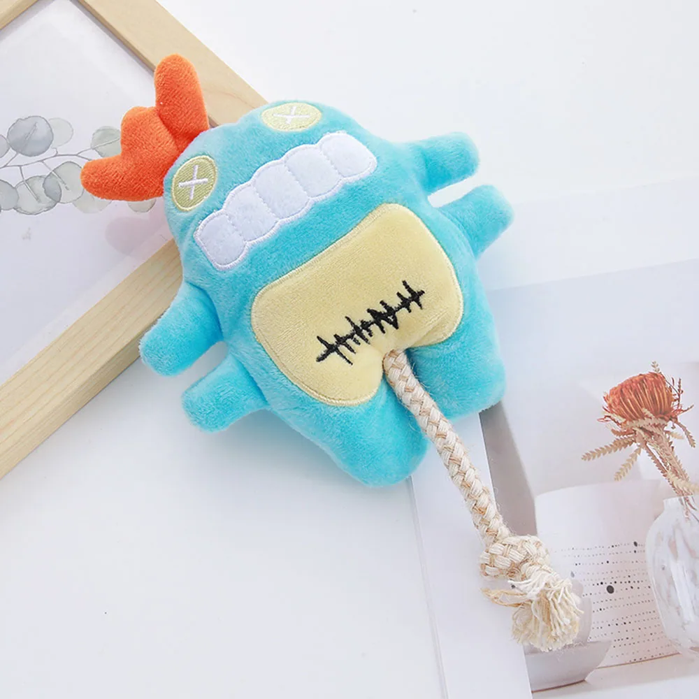 Blue plush monster toy with orange horns and a rope tail
