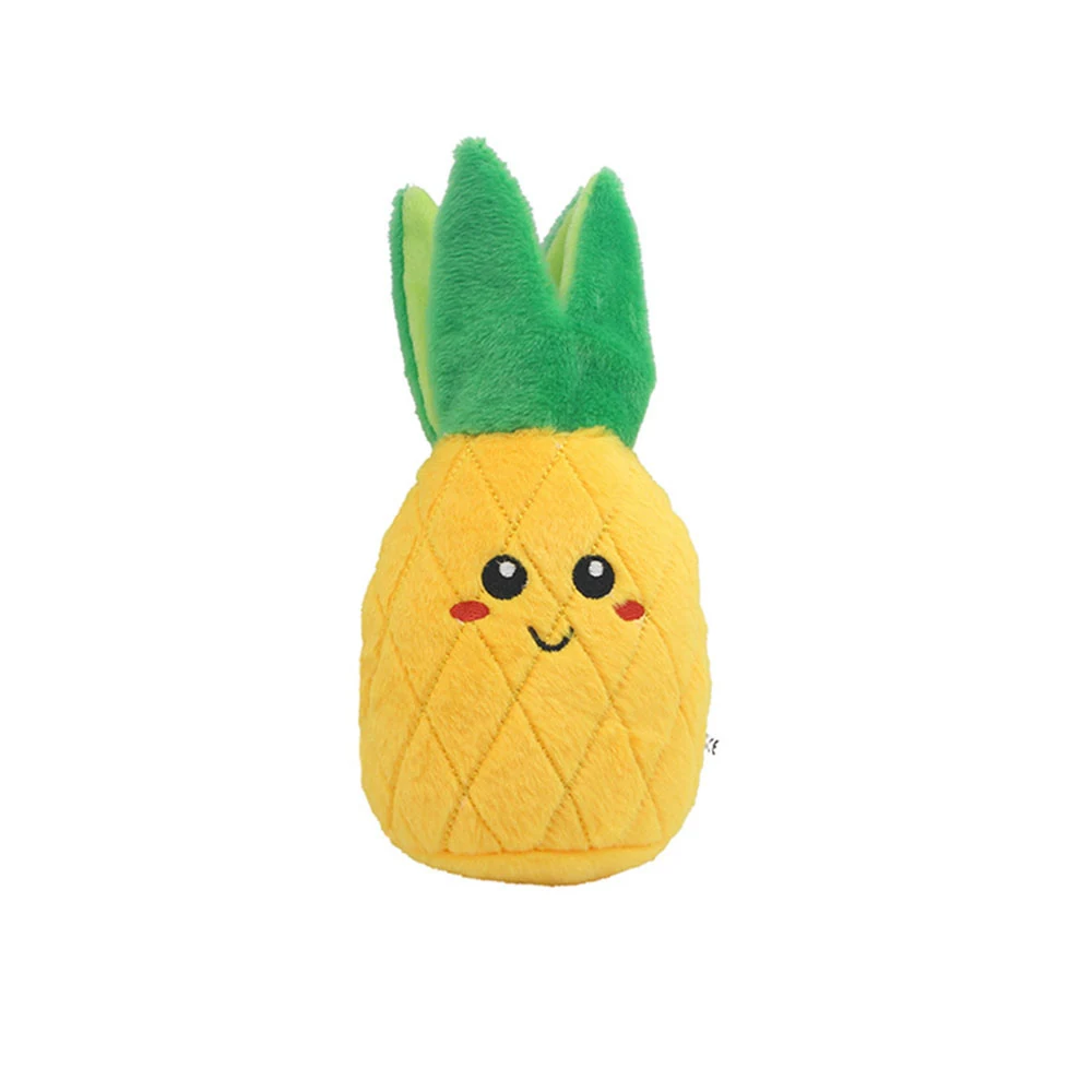 Yellow pineapple plush toy with green leaves and an embroidered face on a white background