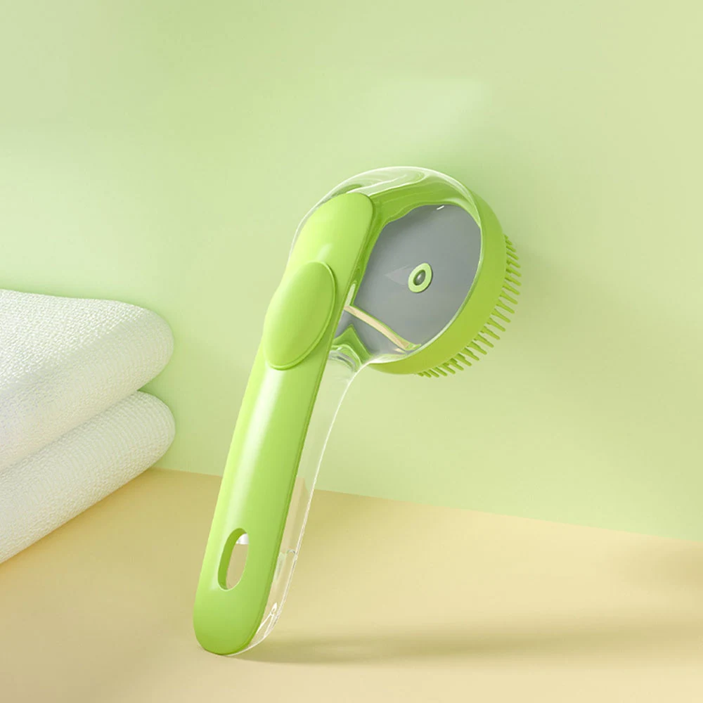 Green pet grooming brush with a clear protective cover and self-cleaning button, resting on a beige surface near a white towel.