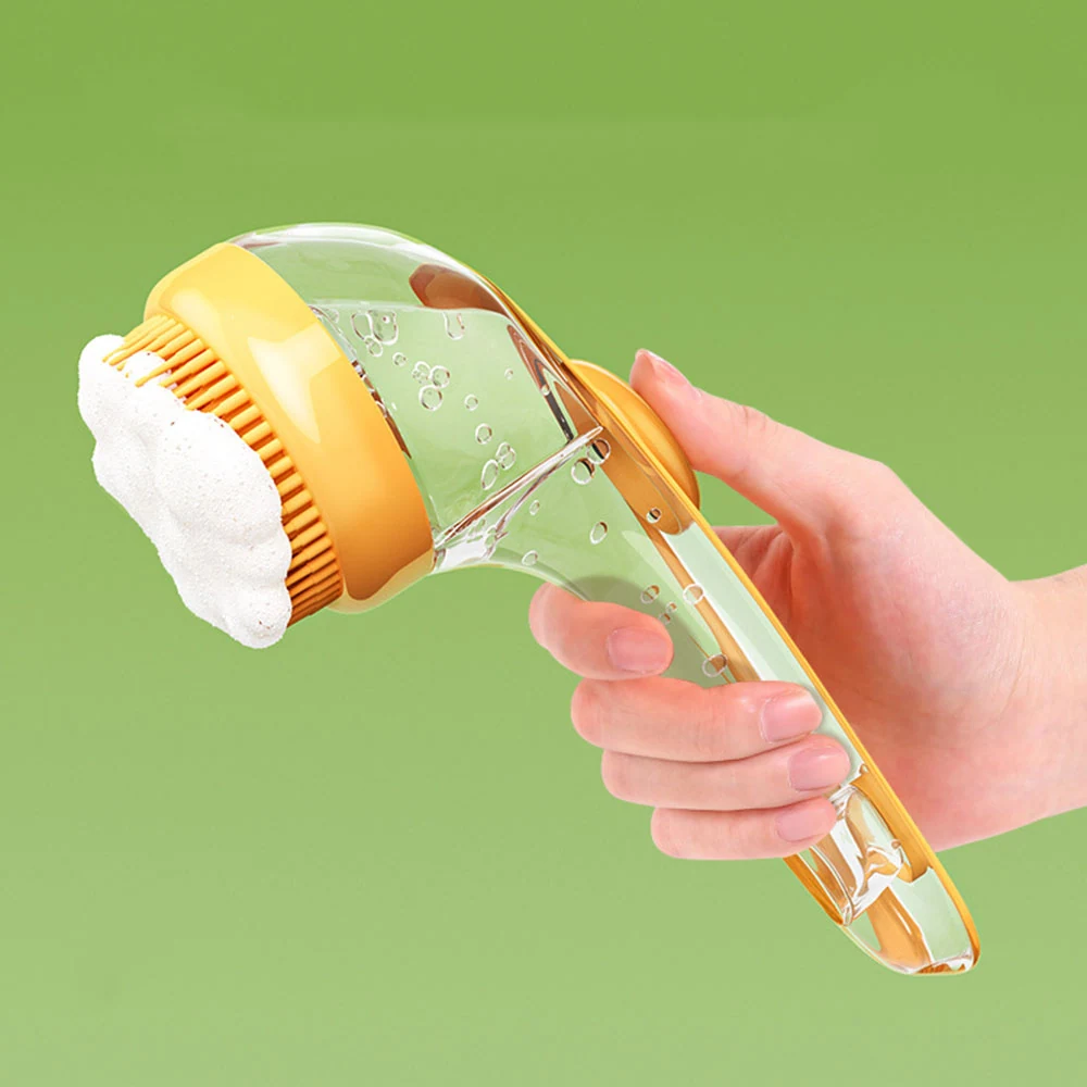 A hand holding a yellow and clear automatic soap dispenser brush covered in foam