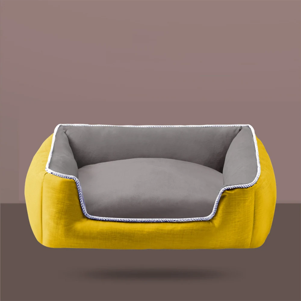 Yellow rectangular pet bed with grey cushion and white braided trim against a brown background