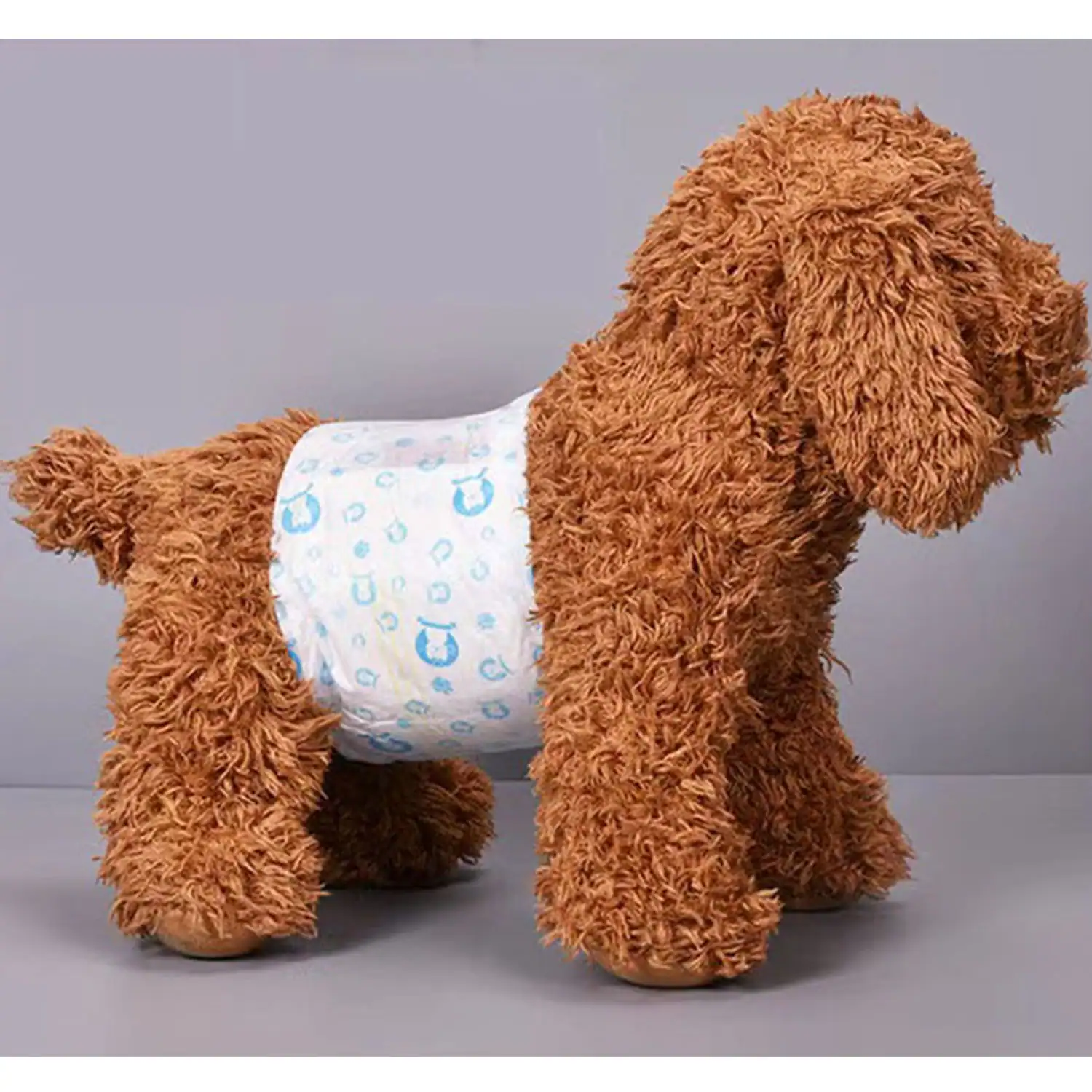 Brown plush dog toy wearing a white diaper with blue patterns