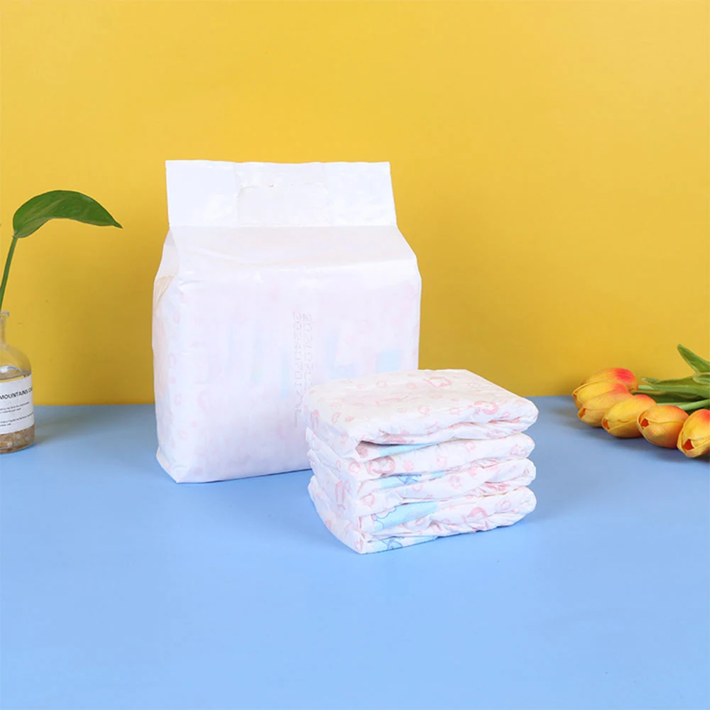 Stacked folded diapers and a large package against a yellow and blue background with decorative tulips.