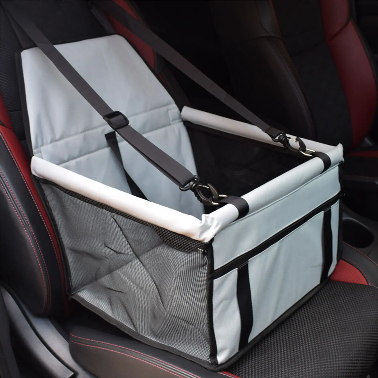 Light grey car seat booster with safety straps installed on a vehicle seat