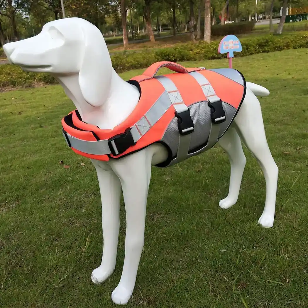 Orange and grey dog life vest with reflective strips displayed on a white mannequin in a park.