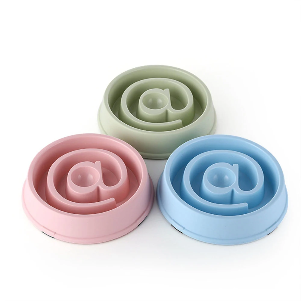 Three silicone slow feeder bowls in pastel pink, blue, and green arranged on a white background