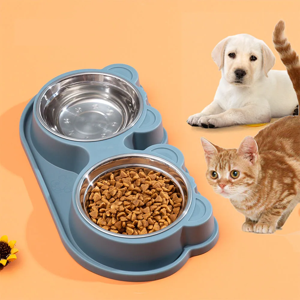 A grey double pet feeder with two stainless steel bowls containing water and food, accompanied by a puppy and a cat.