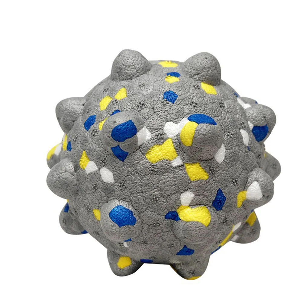 A gray textured spiky ball with yellow, blue, and white markings.