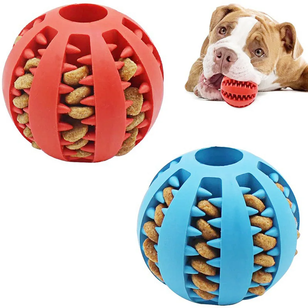 Red and blue silicone dog treat dispensing balls with kibble inside and a dog holding a red ball