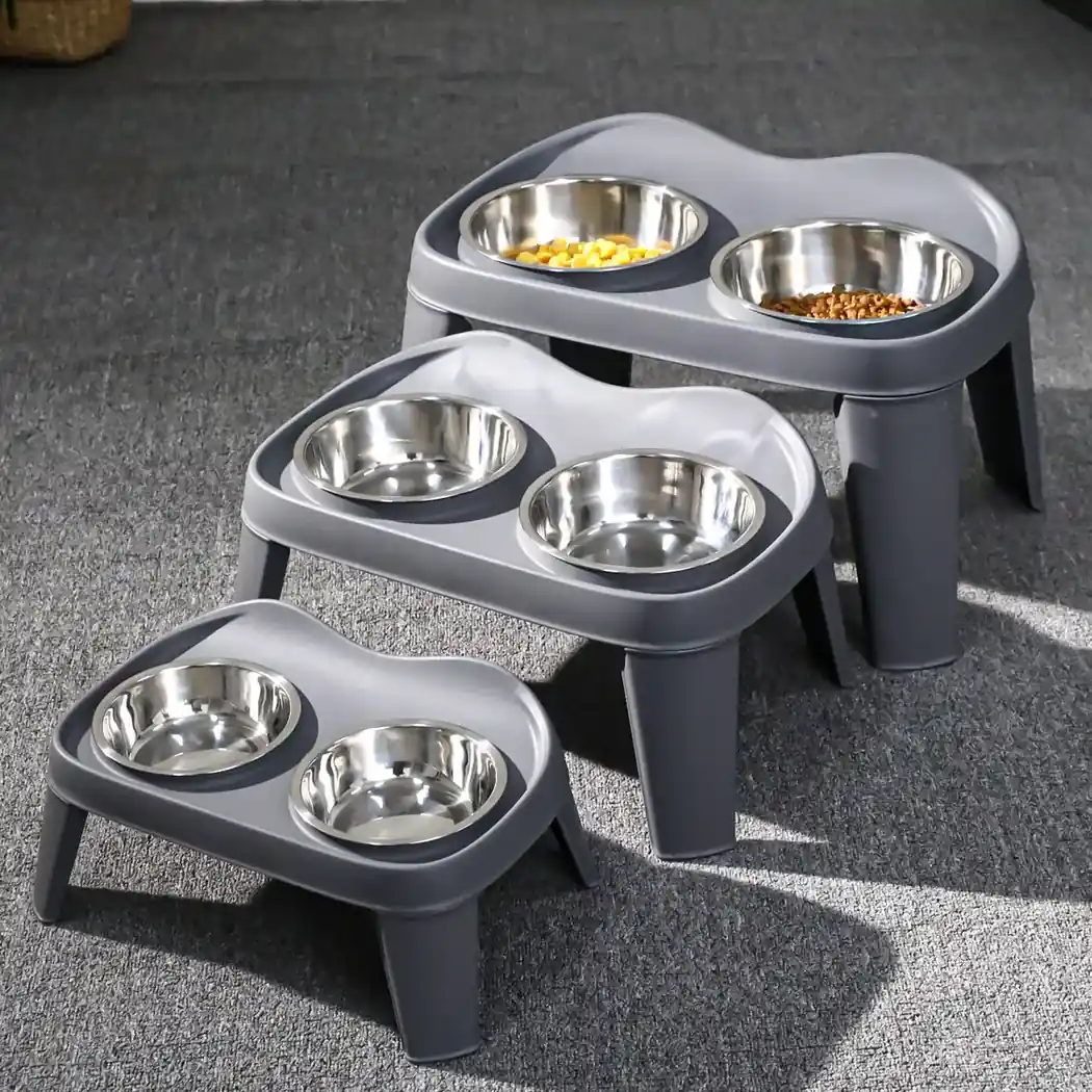 Three grey raised double dog bowl stands with stainless steel bowls in three sizes.