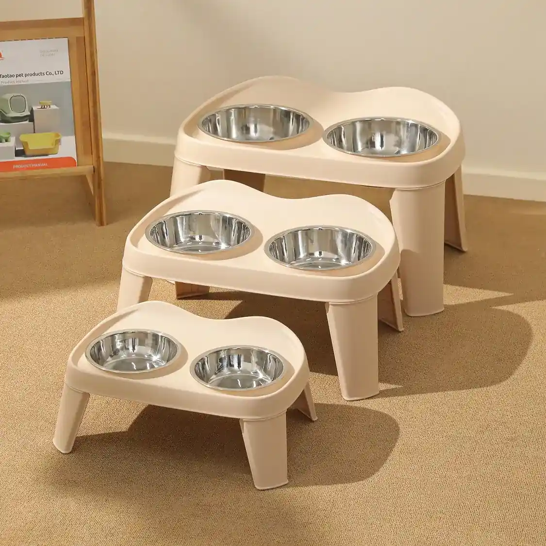 Three beige elevated pet feeding stands with stainless steel bowls arranged by size