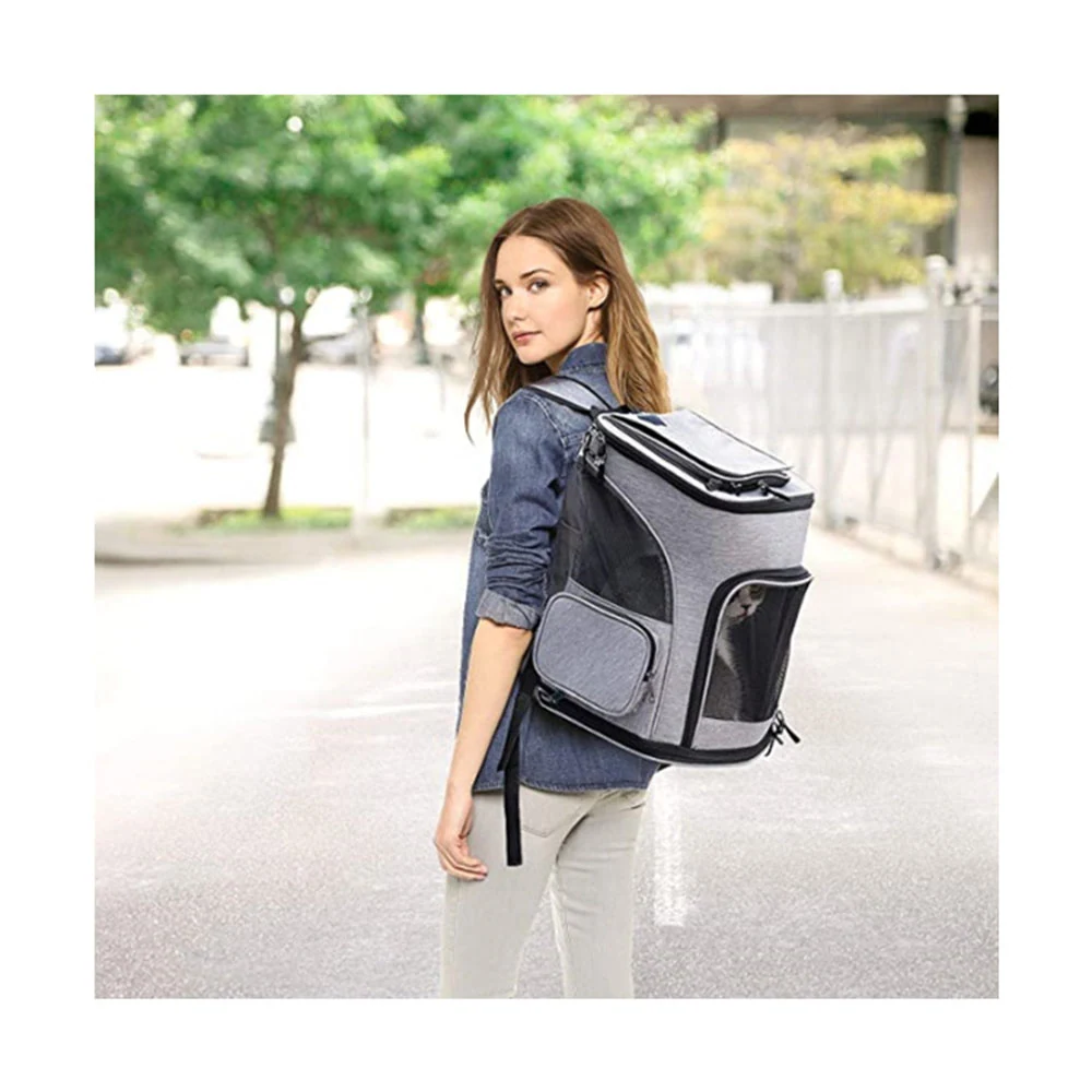 Woman wearing a grey and black pet carrier backpack outdoors