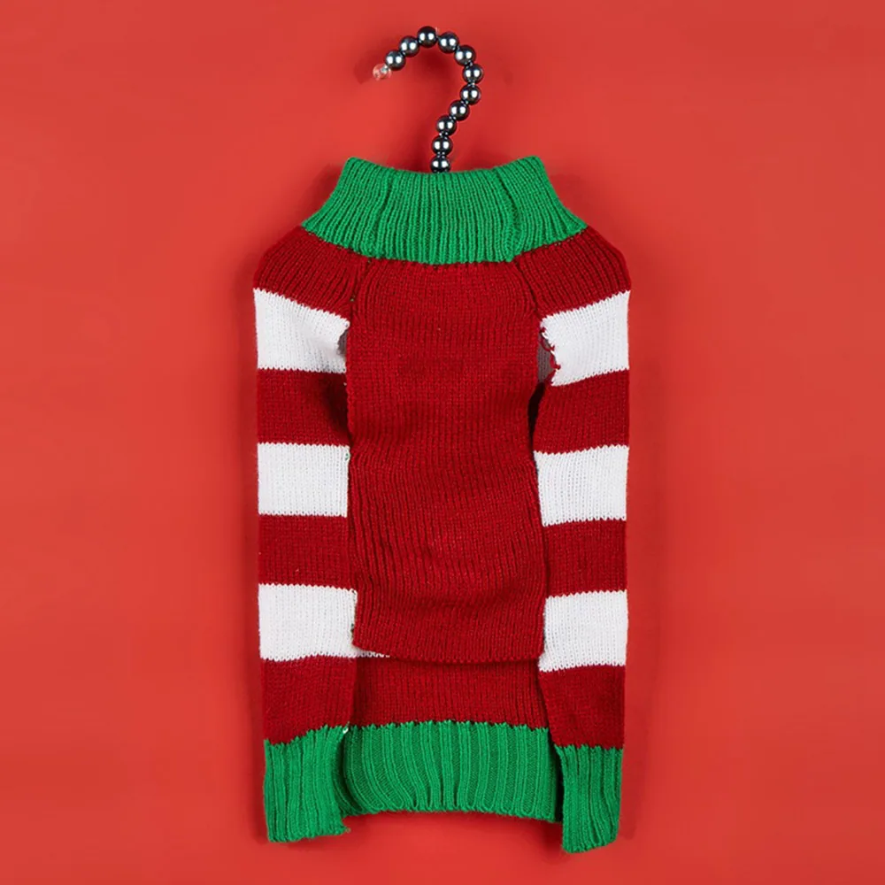Red, white, and green striped knitted sweater hanging on a hook against a red background