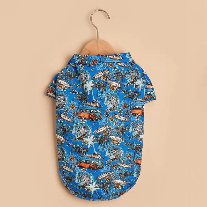 A blue patterned pet shirt hanging on a wooden hanger against a beige background.