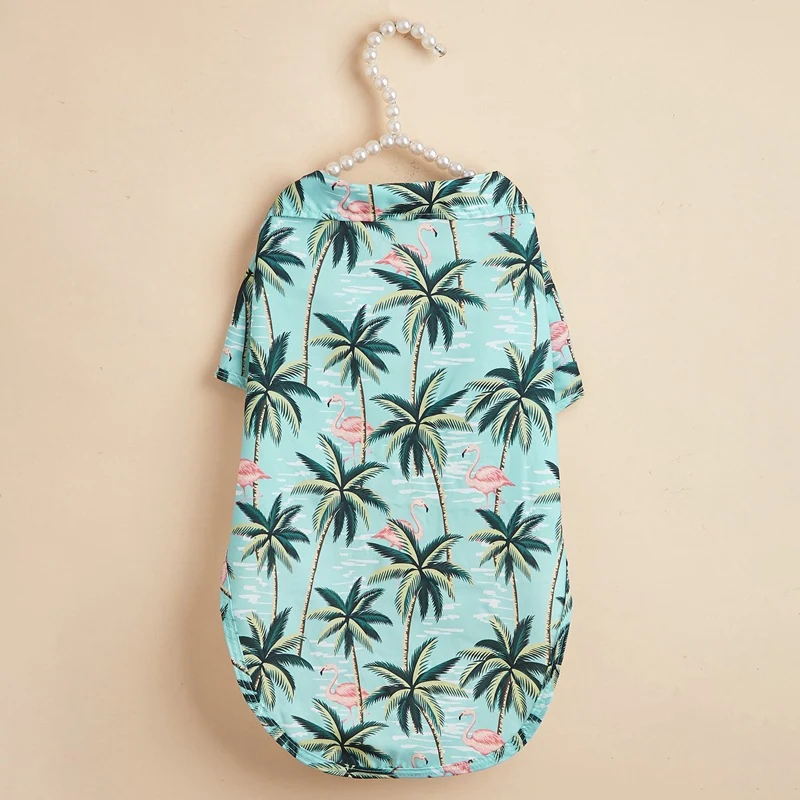 Light blue pet shirt with palm tree and flamingo pattern hanging on a pearl hanger