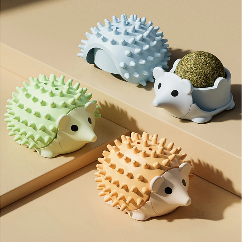 Four spiky hedgehog-shaped catnip dispensers in pastel colors on a tiered beige background.