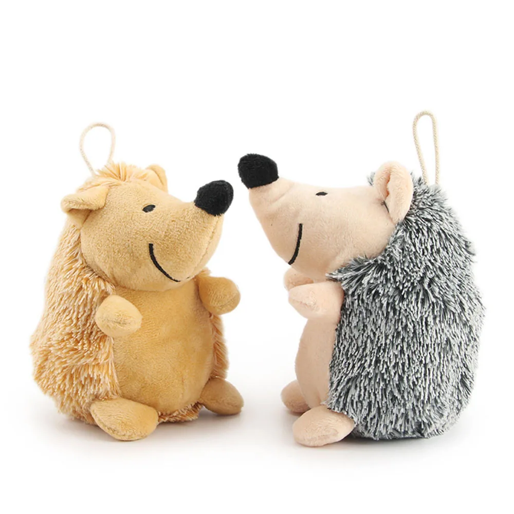 Two plush hedgehog toys with loop hangers, one tan and one grey, facing each other on a white background