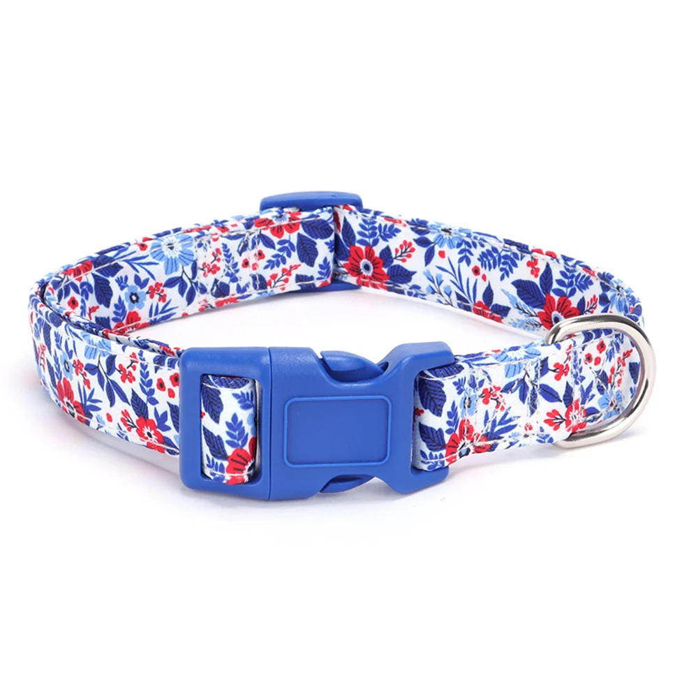 A dog collar with a blue, red, and white floral pattern, a blue plastic buckle, and a metal D-ring.
