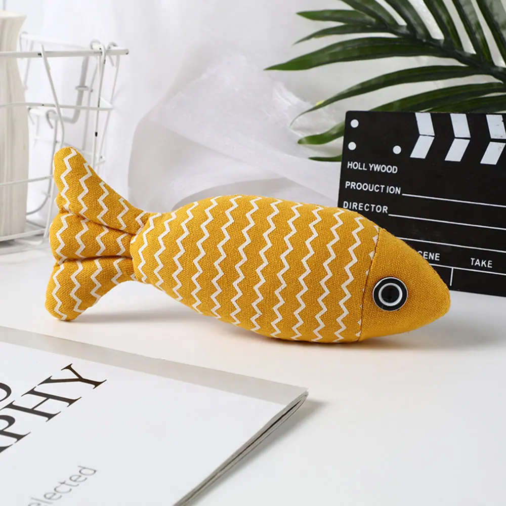 Yellow fabric fish toy with white zigzag pattern and black button eye