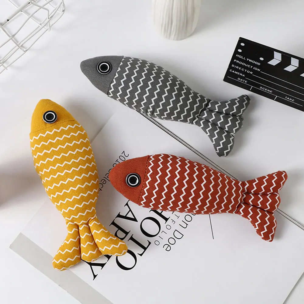 Three plush fish toys with chevron patterns in yellow, grey, and red.