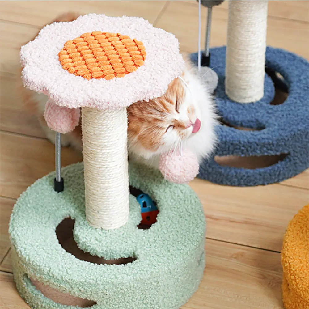 Orange and white cat licking a pink toy on a flower-shaped cat tree scratching post