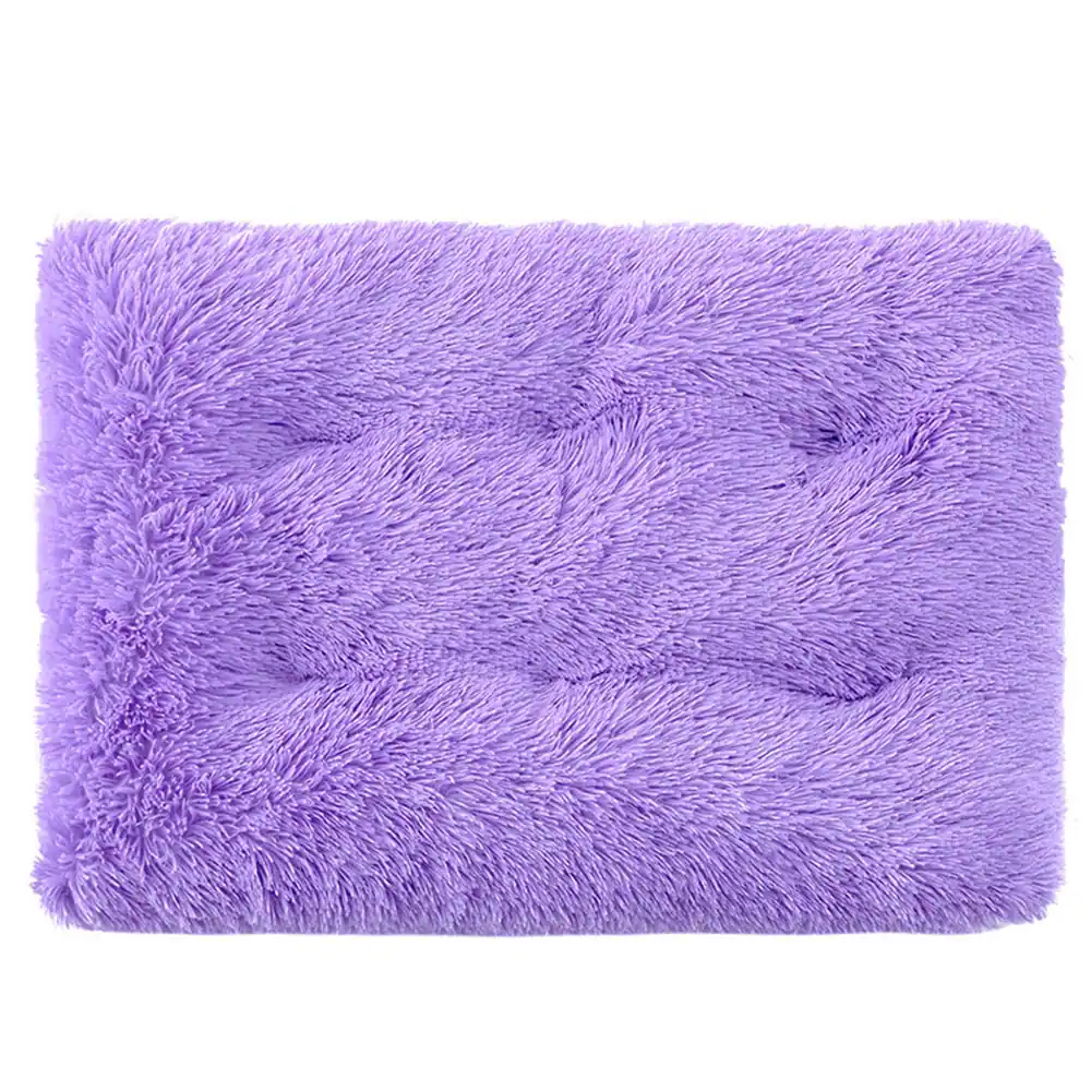 A rectangular purple tufted rug with a soft, shaggy texture and a buttoned pattern.
