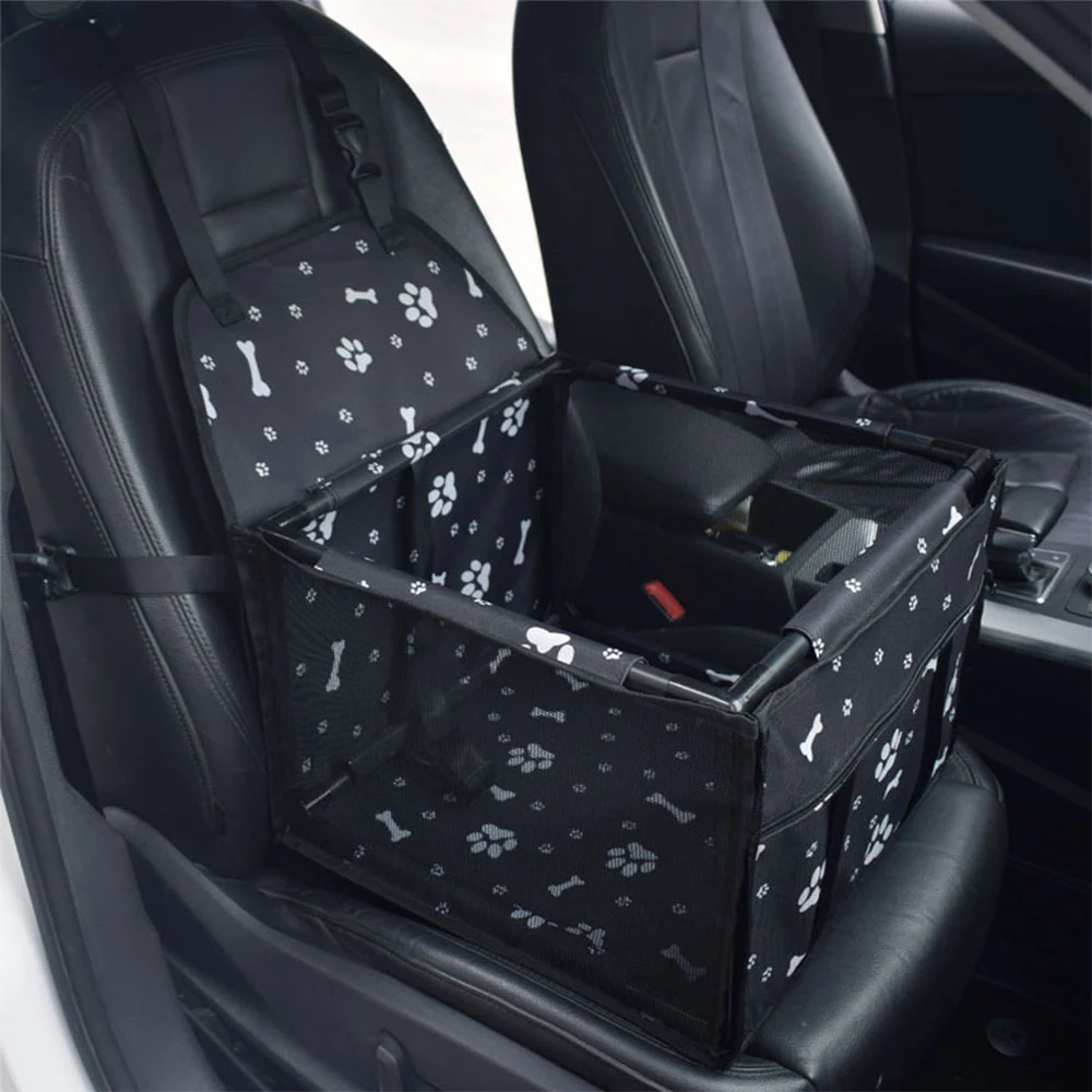 Black pet car seat cover with white paw print and bone pattern installed on a car seat