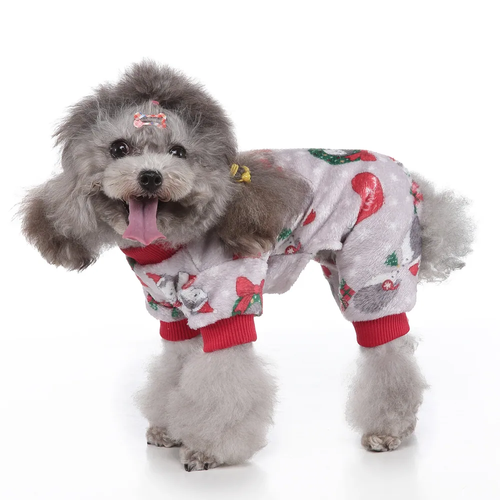 Grey poodle wearing a white Christmas themed fleece jumpsuit with red cuffs and ornaments.