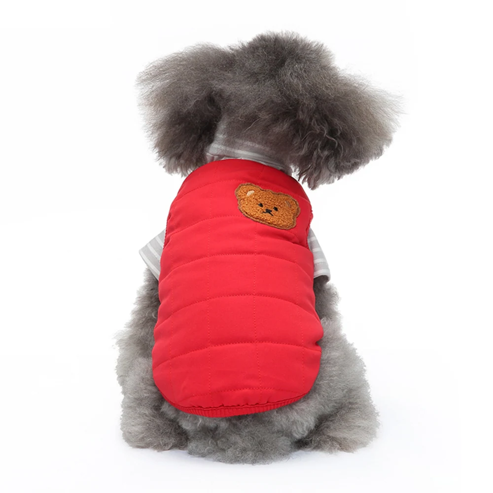 Rear view of a fluffy grey dog wearing a red puffer vest with a brown bear patch on the back