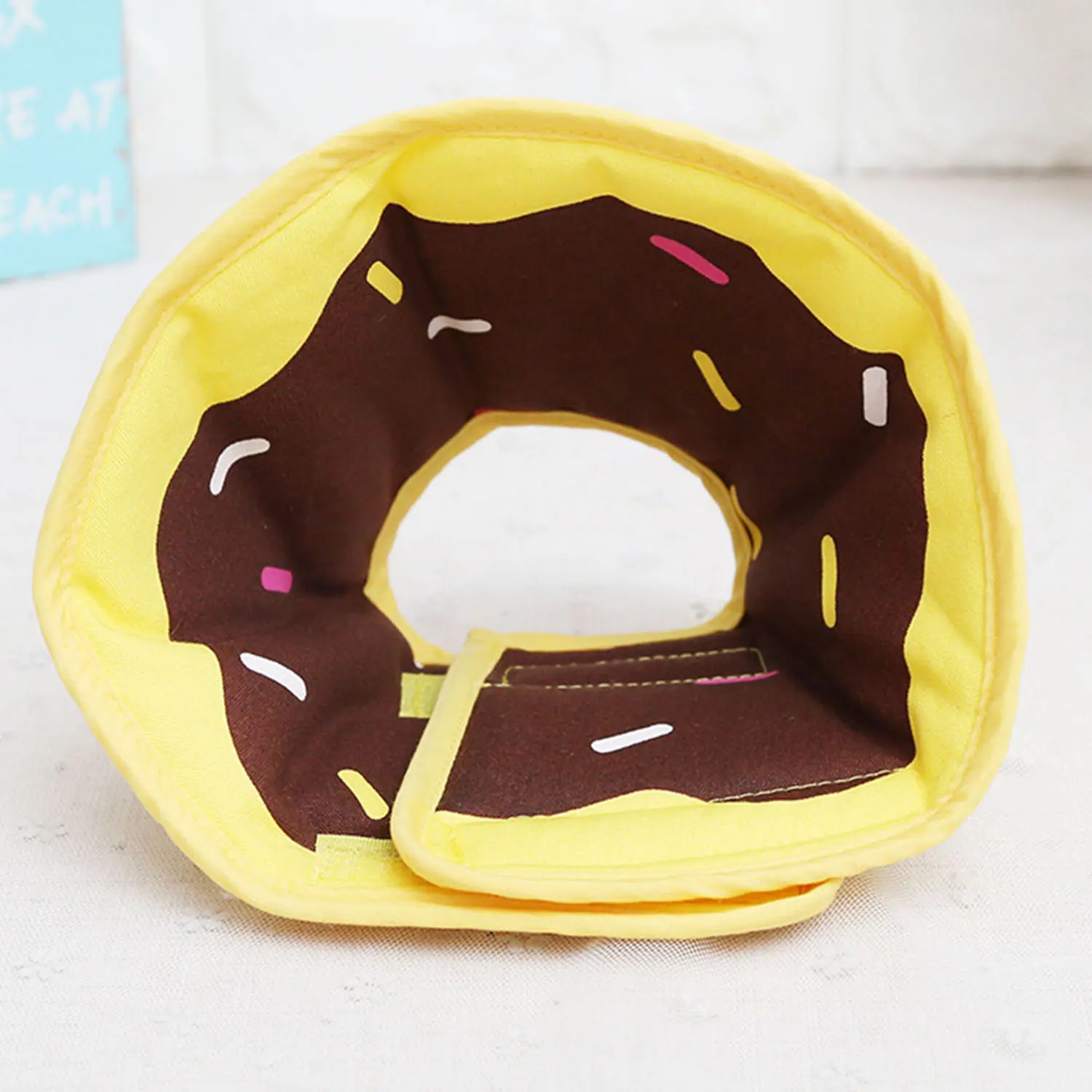 Yellow and brown donut-shaped fabric pet collar with sprinkle details