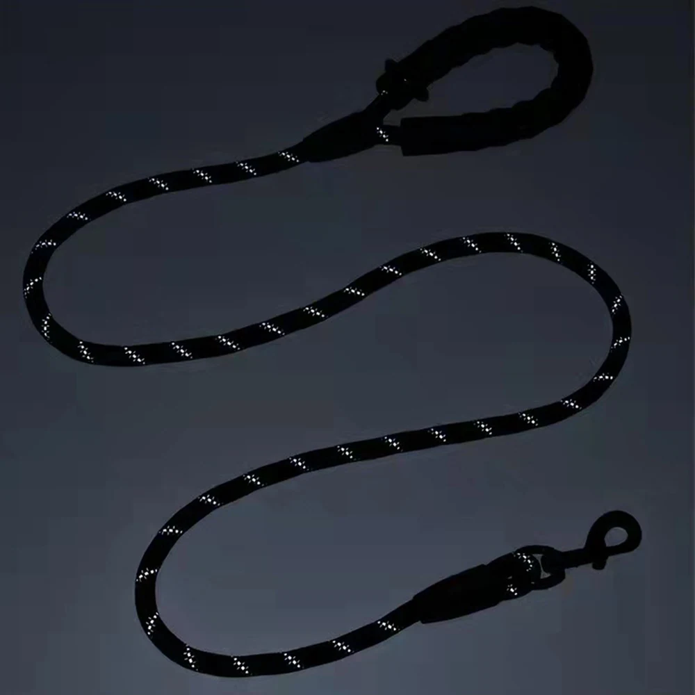 Black rope with reflective stitching and metal clip, coiled in an S-shape on a dark surface