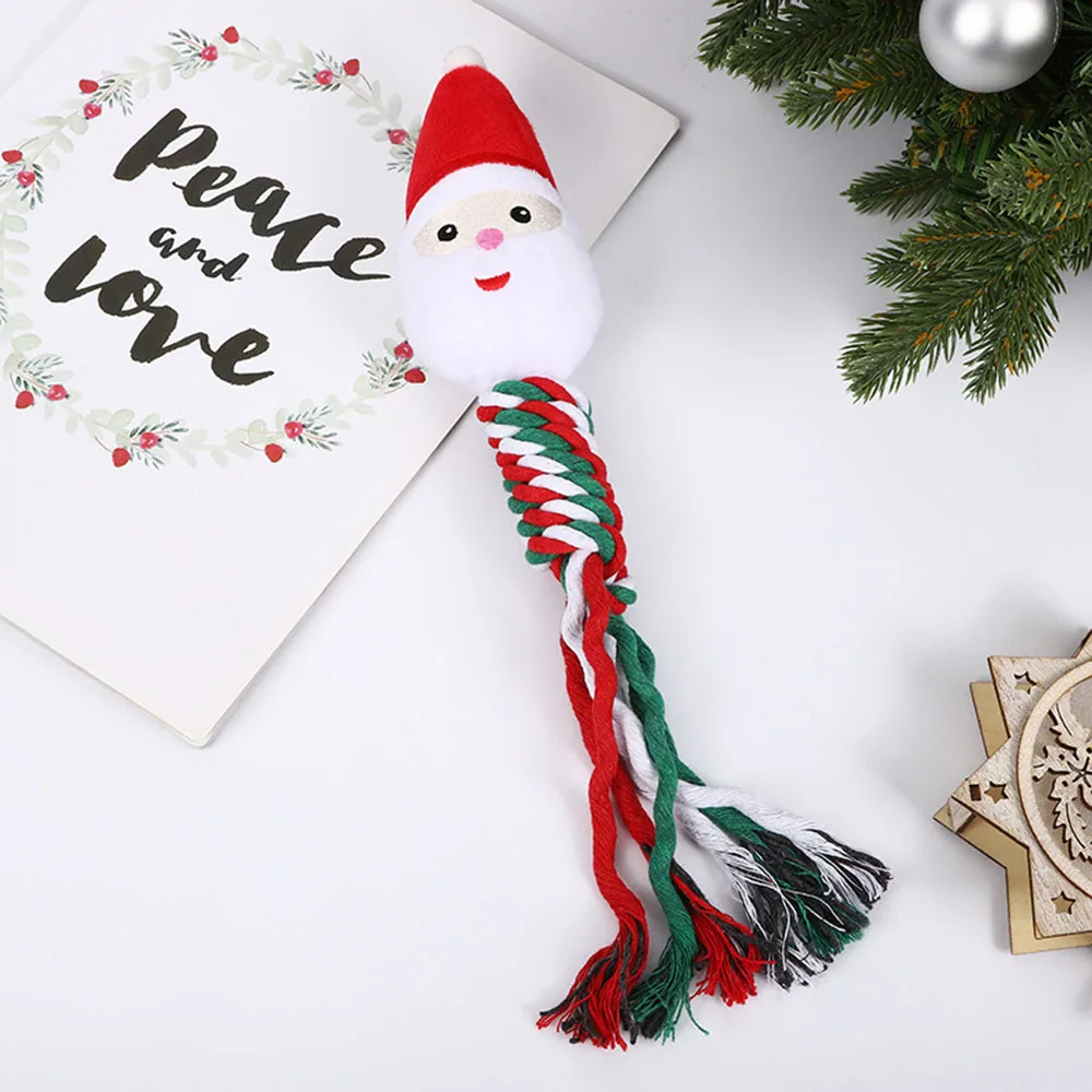 A plush Santa head dog toy with a red, green, and white braided rope body on a white surface.