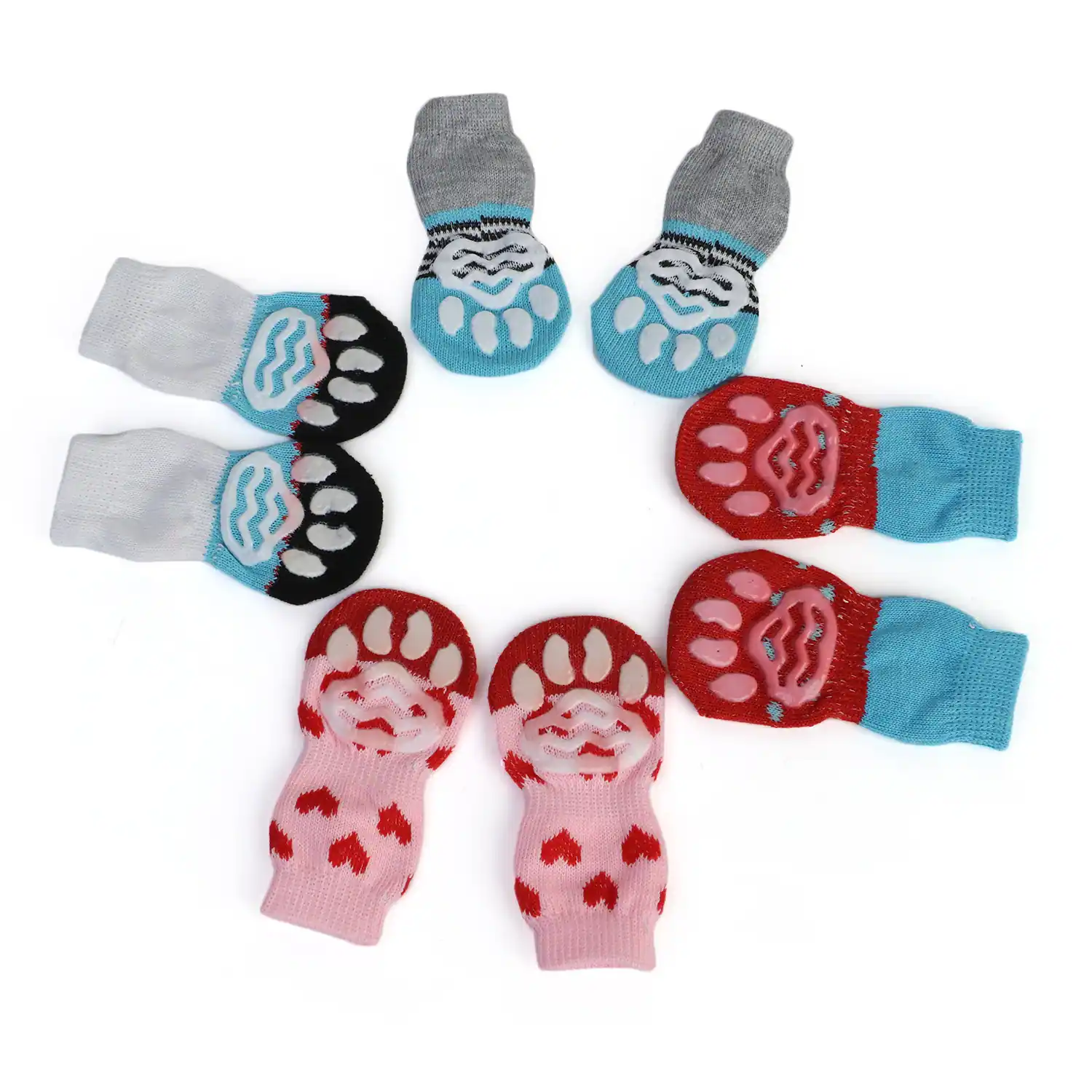 A collection of knitted dog socks in grey, red, and pink arranged in a circle