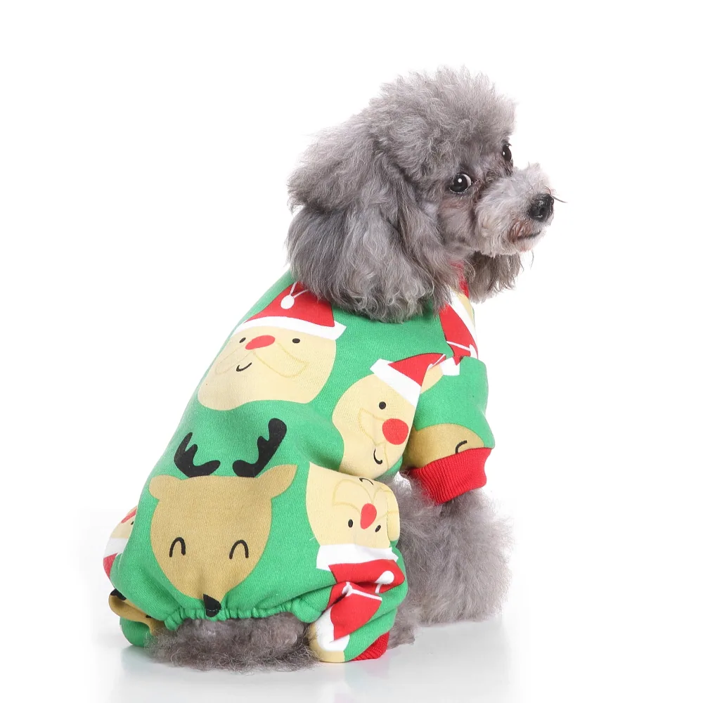 Grey poodle wearing a green Christmas sweater with Santa and reindeer faces