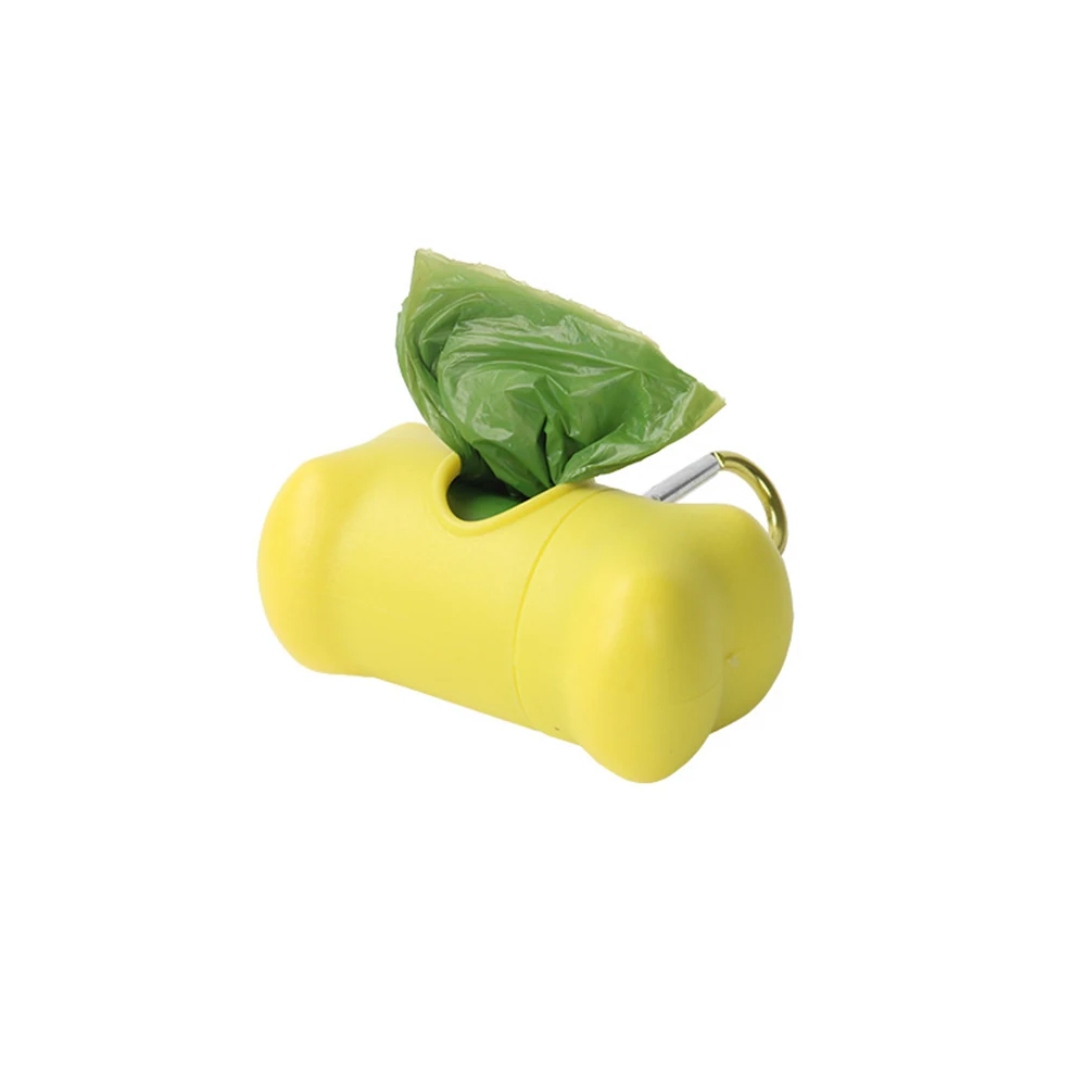 Yellow bone-shaped plastic dispenser with green bags and metal clip on white background