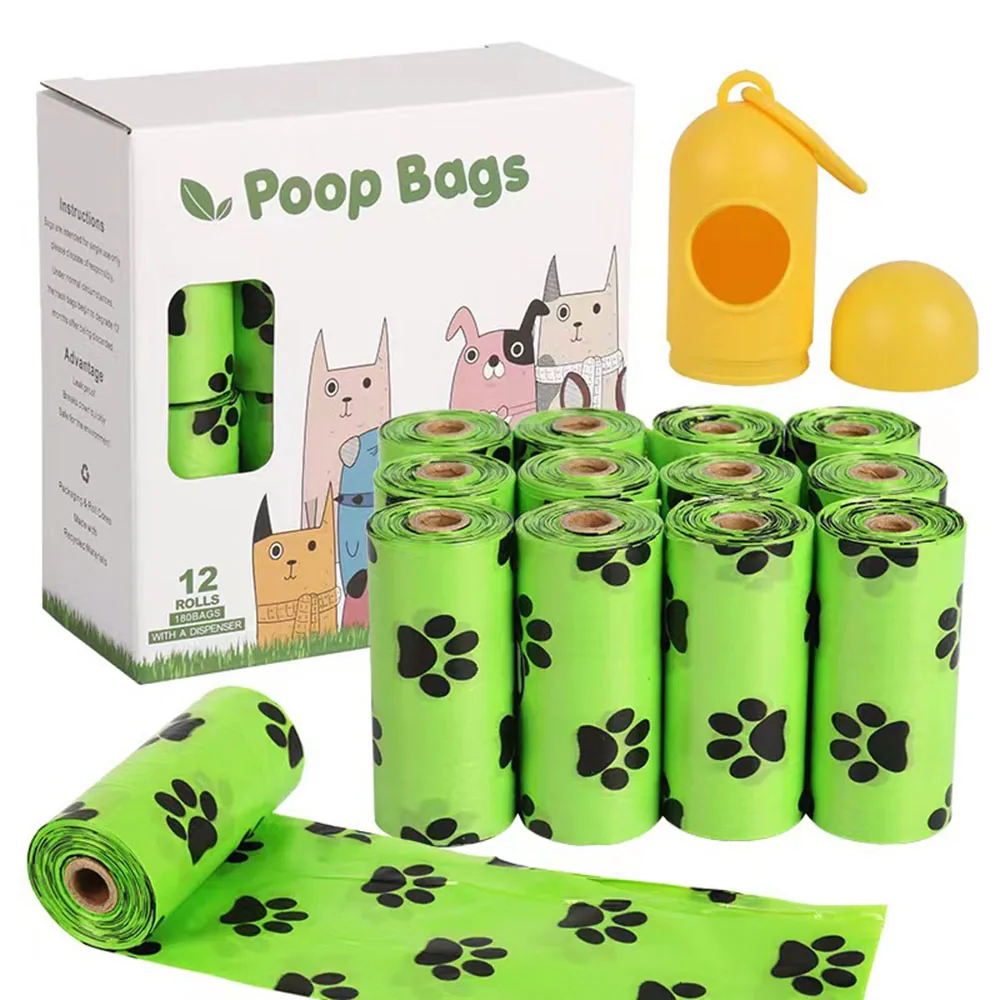 Pack of 12 rolls of green dog waste bags with paw prints, box packaging, and yellow dispenser.