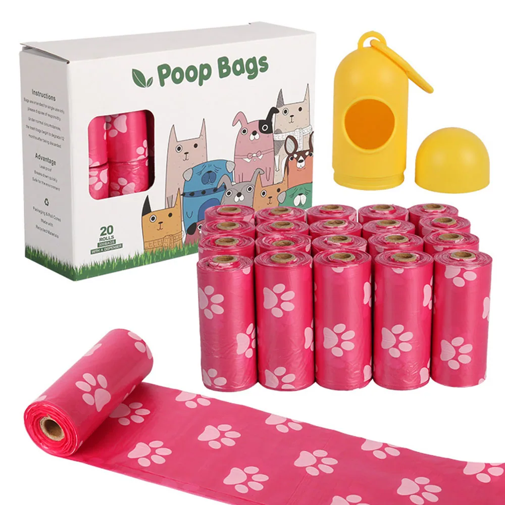 Box of pink dog waste bags with paw print pattern, unrolled sheet, and yellow dispenser